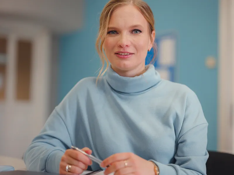 Eine Frau sitzt am Schreibtisch und bespricht im Video-Call ihre hormonellen Beschwerden mit einer Expertin der Online-Hormonberatung von Hormonice.